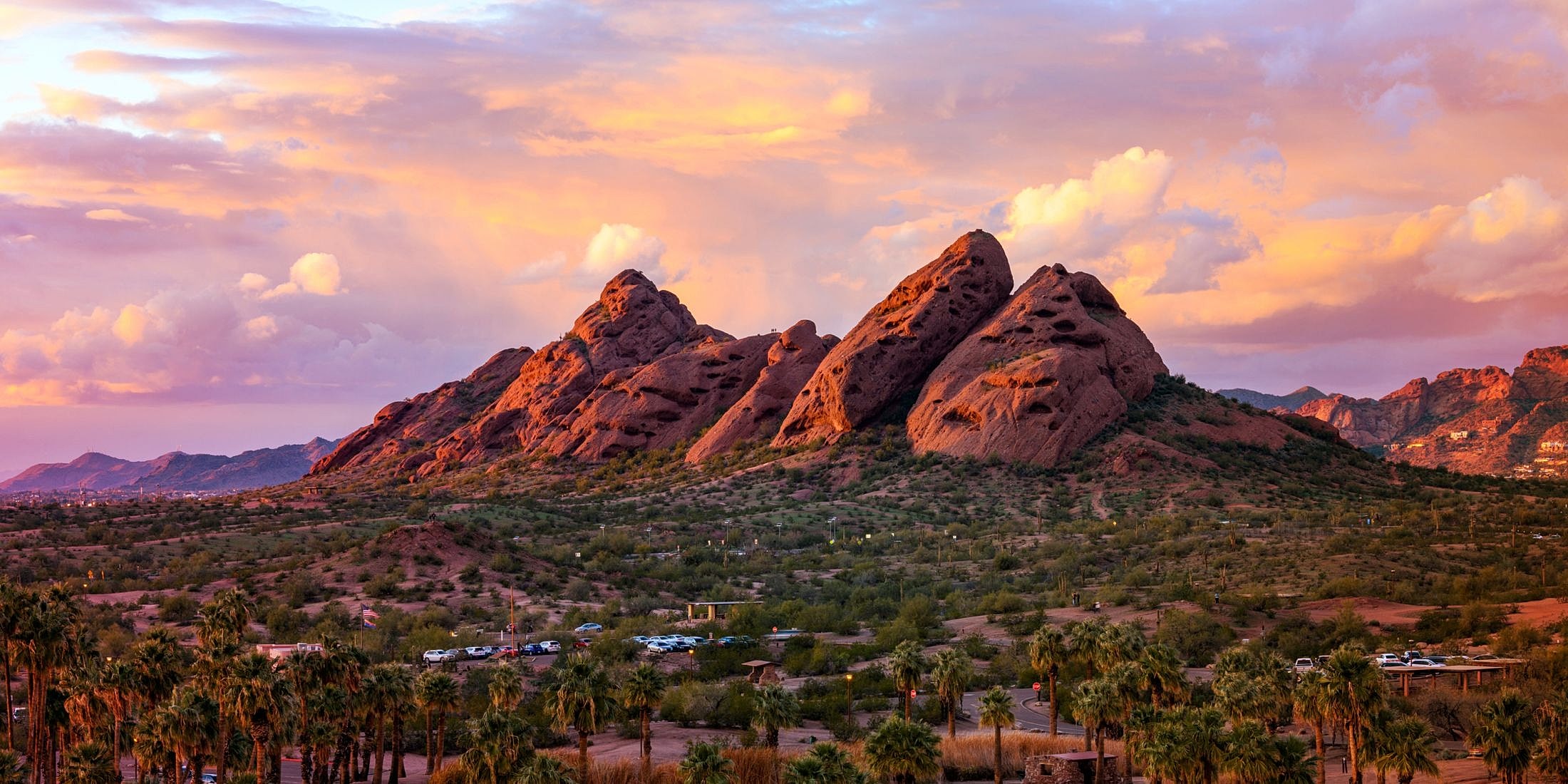 Desert mountains under colorful sunset sky.
