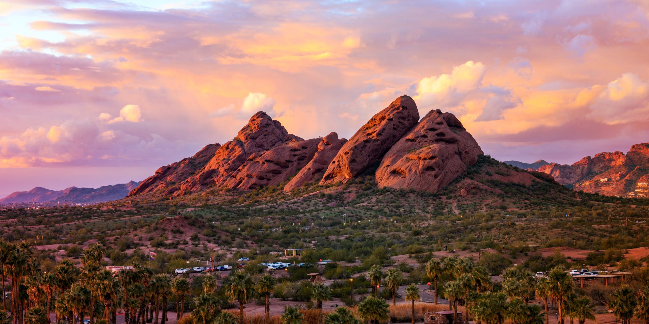 Desert landscape with mountains and colorful sky.