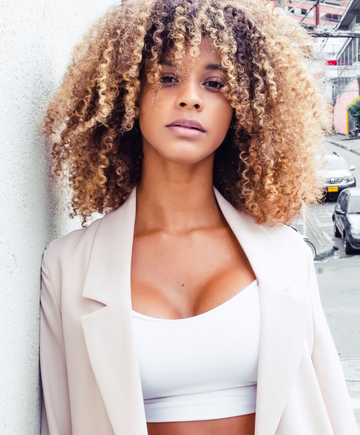 Woman with curly hair in stylish outfit.
