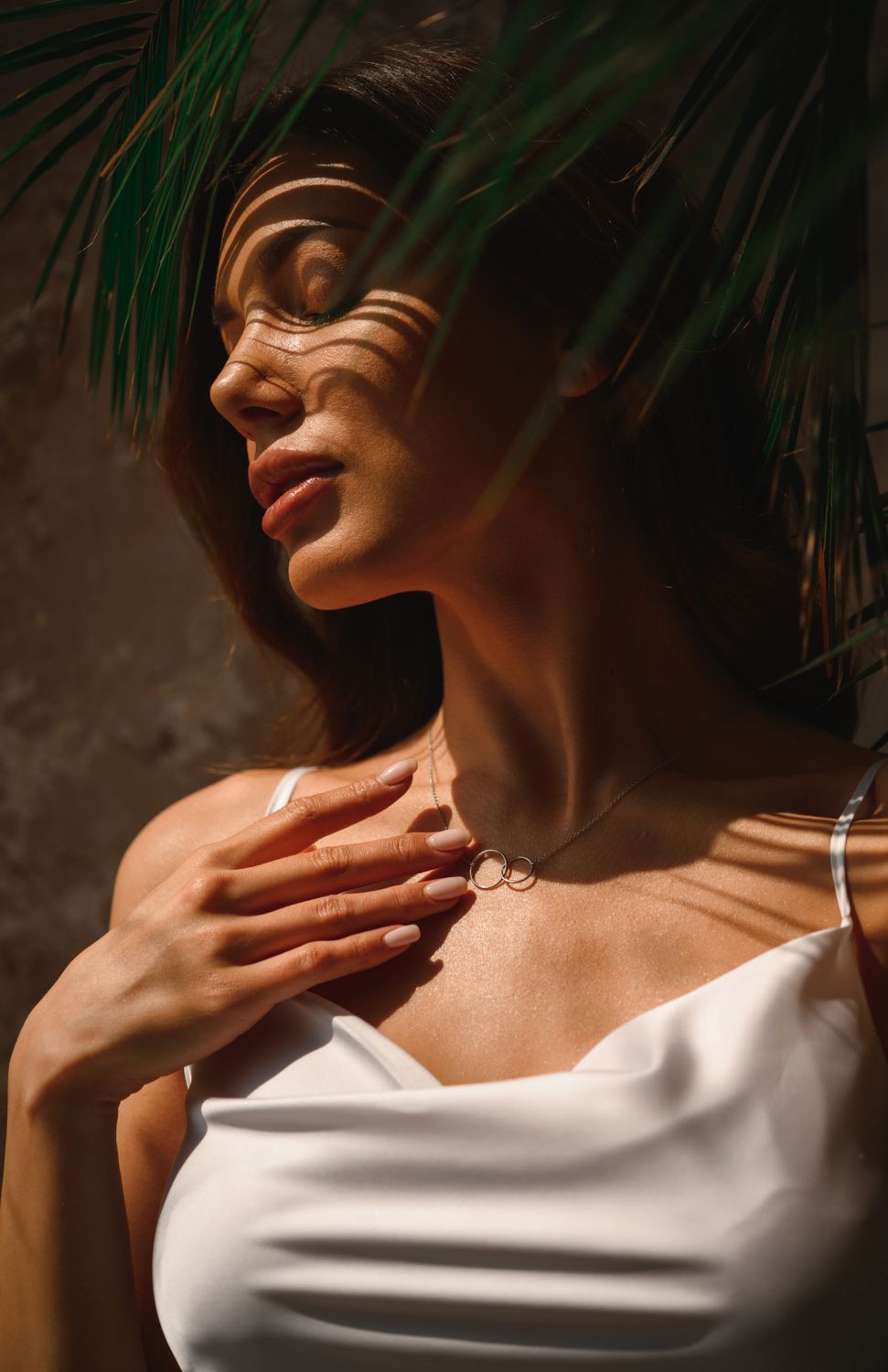 Phoenix plastic surgery model in sunlight with shadows and necklace.